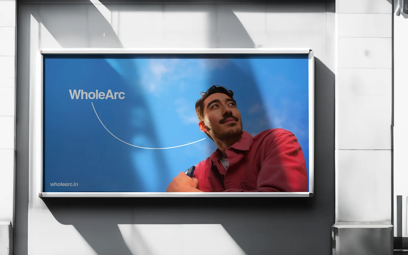 A billboard of a man in red against a blue sky, framed by the arc.